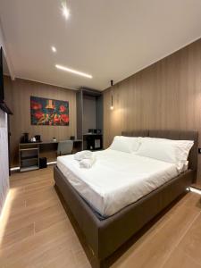 a bedroom with a large bed and a desk at Il Tempio Luxury Rooms in Cosenza