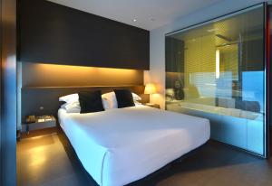 a bedroom with a white bed and a large window at Hotel Soho in Barcelona