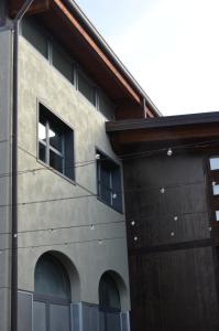 a building with two windows on the side of it at Tenuta Roletto Cascina Guie in Cuceglio