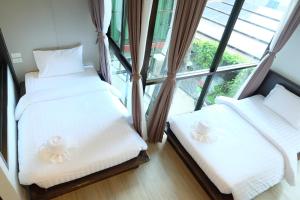 two beds in a room with a large window at A Plus Deluxe Hotel in Ko Lipe