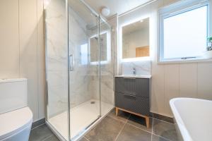 a bathroom with a shower and a toilet and a sink at Barton Lodge in Penrith +18 photos