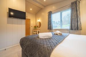 a bedroom with a bed with two towels on it at Barton Lodge in Penrith