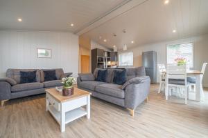 a living room with two couches and a table at Barton Lodge in Penrith
