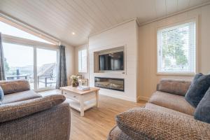 a living room with two couches and a tv at Barton Lodge in Penrith