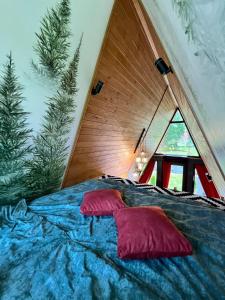 a bed with two pillows on it in a room at A-frame-hub з форелевою риболовлею in Slavske
