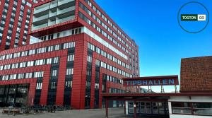 a tall red building with a sign in front of it at Nice Växjö City Stay In Arenastaden Vida Arena in Växjö