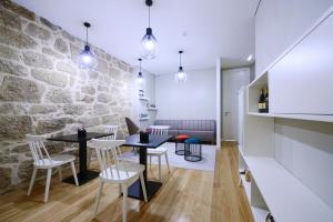 a room with two tables and chairs and a stone wall at VILA DE PONTE GUEST HOUSE in Ponte de Lima
