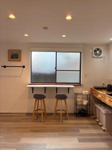 a room with two stools in front of a window at 細島 Base Clutch in Hyuga