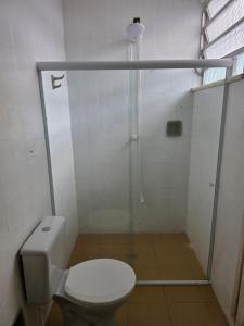 a bathroom with a toilet and a shower stall at Quarto Ametista in Aracaju +2 photos