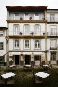 a building with tables and chairs in front of it at VILA DE PONTE GUEST HOUSE in Ponte de Lima