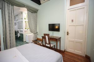 a bedroom with a bed and a desk and a television at Hotel A&B Internacional in Buenos Aires