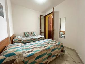 a bedroom with two beds and a mirror at 48 Trilocale vista mare in Bellaria-Igea Marina