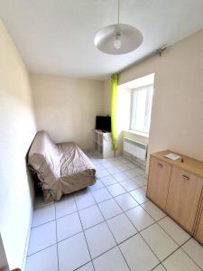a bedroom with a bed on a tiled floor at Gîte La Vallée RDC Neyrac-les-Bains in Meyras