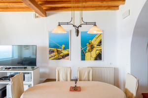 a dining room with a table and two paintings on the wall at Lighthouse Villa - Private Pool - Unlimited Sea View - 6 pax in Houlakia