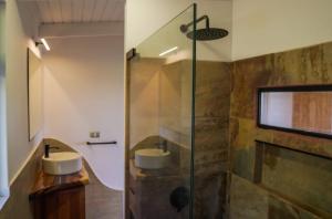 a bathroom with two sinks and a glass shower at Te Manu Lodge in Hanga Roa