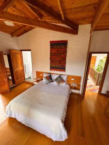 a bedroom with a large bed in a room with wooden floors at Terrazas de Salento in Salento +30 photos