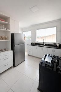 a kitchen with a stainless steel refrigerator and a stove at Apê 301 - Central, Garagem, Ar-Cond - 2 Quartos in Governador Valadares +5 photos