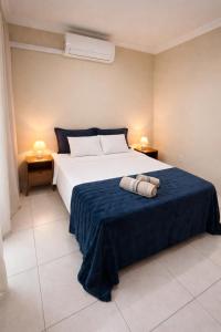 a bedroom with a bed with two towels on it at Apê 301 - Central, Garagem, Ar-Cond - 2 Quartos in Governador Valadares