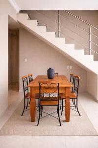 a dining room table with four chairs and a staircase at Apê 301 - Central, Garagem, Ar-Cond - 2 Quartos in Governador Valadares