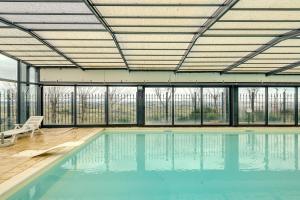 an indoor swimming pool with a roof and windows at Villa Fefa by MMega in Tolentino +37 photos