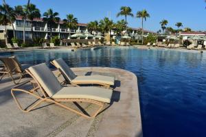 two lounge chairs sitting next to a swimming pool at Pierre Mundo Imperial Riviera Diamante Acapulco in Acapulco +83 photos
