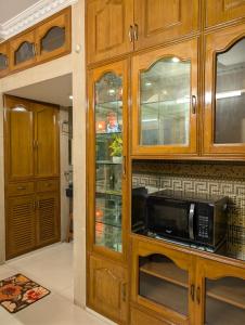a kitchen with wooden cabinets and a microwave at 3 ac Bedroom in Dhaka