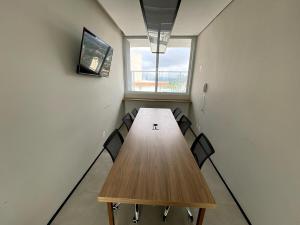 a conference room with a wooden table and chairs at Central Studio in the metro Butantã in São Paulo +1 photo