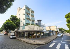 a building on a street with cars parked on the street at Apê 301 - Central, Garagem, Ar-Cond - 2 Quartos in Governador Valadares