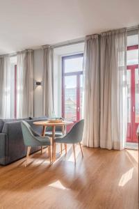 a living room with a couch and a table and chairs at Uma Formosa Apartments in Porto