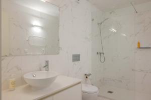 a white bathroom with a sink and a shower at Uma Formosa Apartments in Porto