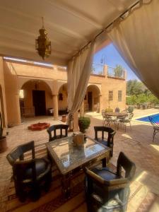 a patio with a table and chairs and a pool at Riad Jardin des Orangers in Taroudant