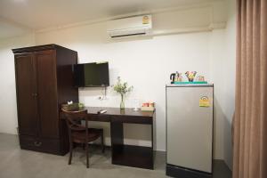 a kitchen with a desk and a refrigerator and a table at SU 22 in Bangkok