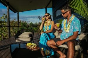 a man and a woman sitting on a porch with drinks at Te Manu Lodge in Hanga Roa +7 photos