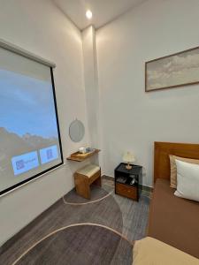 a room with a bed and a table and a window at 1 House 2 in Da Lat
