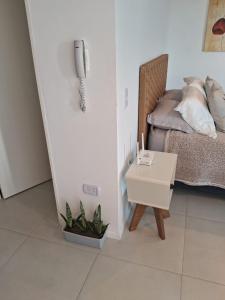 a room with a bed and a table with a phone at Metra DS Puerto Norte in Rosario +15 photos