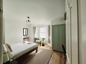 a bedroom with a bed and a green cabinet at Saint Margaret's Guest House - Comfortable Rooms in a Quiet Area Close to the Heart of Poole - Free Parking & Fast Wifi in Poole +23 photos