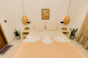 a bedroom with a bed with two towels on it at Cafe San-Khara in Ahangama