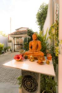 a statue of a buddha sitting on a table at Cafe San-Khara in Ahangama
