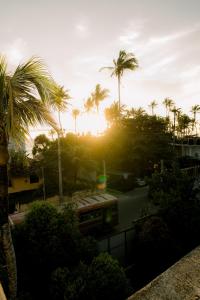 a sunset with palm trees and a train at Cafe San-Khara in Ahangama