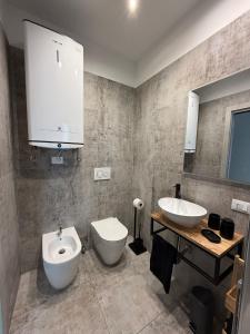 a bathroom with two sinks and a toilet and a mirror at R Apartment - Venaria in Venaria Reale