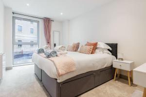 a bedroom with a large bed and a window at Once Upon a Tide - Stylish Apartment in the Heart of Poole in Poole