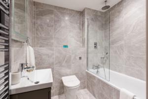 a bathroom with a toilet and a tub and a sink at Once Upon a Tide - Stylish Apartment in the Heart of Poole in Poole