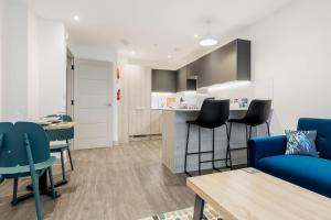 a living room with a blue couch and a kitchen at Once Upon a Tide - Stylish Apartment in the Heart of Poole in Poole