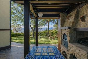 an open patio with a stone fireplace in a house at Villa Fefa by MMega in Tolentino