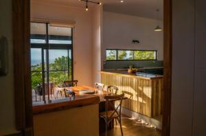 a kitchen with a table and a counter with chairs at Te Manu Lodge in Hanga Roa