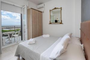 a bedroom with a bed with a mirror and a balcony at Hotel Rudy Cervia in Cervia