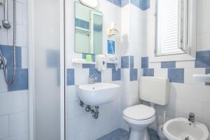 a blue and white bathroom with a toilet and a sink at Hotel Rudy Cervia in Cervia