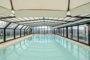 an indoor swimming pool with glass windows and a poolasteryasteryasteryasteryasteryastery at Villa Fefa by MMega in Tolentino