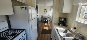 a kitchen with a white refrigerator and a sink at #7 Kipling Cottages Last Resort on Lake Michigan in Gladstone