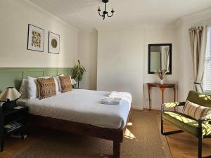 a bedroom with a bed and a chair at Saint Margaret's Guest House - Comfortable Rooms in a Quiet Area Close to the Heart of Poole - Free Parking & Fast Wifi in Poole